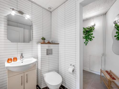 a white bathroom with a toilet and a sink at Holiday Home Ødmar - 4km to the fjord by Interhome in Nørre Nebel