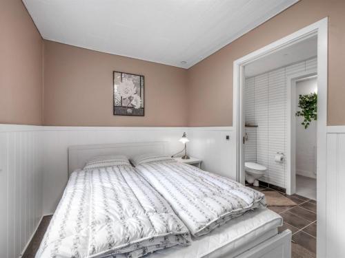 a bedroom with a large bed with a white comforter at Holiday Home Ødmar - 4km to the fjord by Interhome in Nørre Nebel
