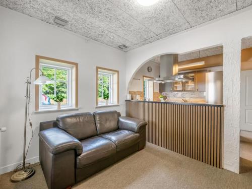 a living room with a couch and a kitchen at Holiday Home Ødmar - 4km to the fjord by Interhome in Nørre Nebel
