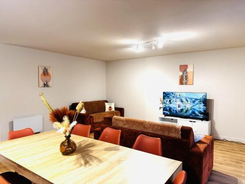 a living room with a table and a couch at Le Terracotta cocon moderne à 2 pas de la Gare ligne directe GENÈVE-LYON-PARIS in Bellegarde-sur-Valserine