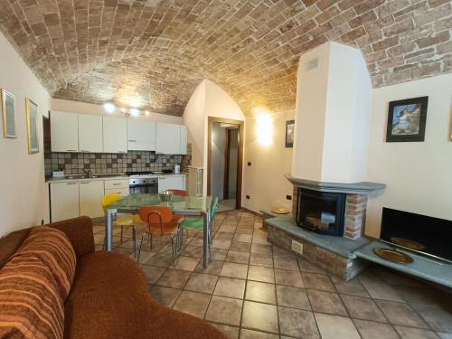 a living room with a couch and a table with a fireplace at Via Angelo Brofferio - Appartamento Centro Storico in Asti