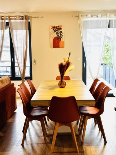 a dining room with a wooden table and chairs at Le Terracotta cocon moderne à 2 pas de la Gare ligne directe GENÈVE-LYON-PARIS in Bellegarde-sur-Valserine