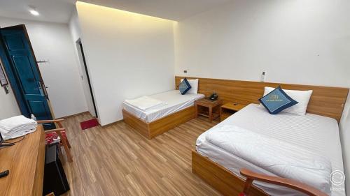 a hotel room with two beds and a desk at Gia Bao Hotel Phu Tho in Việt Trì