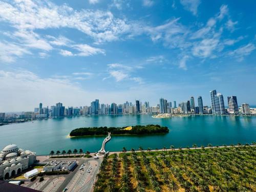 a large body of water with a city in the background at Waterfront Modern loft overlooking downtown 3BR in Sharjah