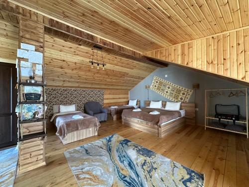 a large room with two beds and a couch at Hotel Nestt in Stepantsminda