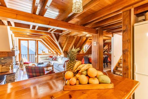 un bol de fruta en una mesa de madera en una habitación en Luxury Familiar Baqueira, en Naut Aran (Alto Arán)