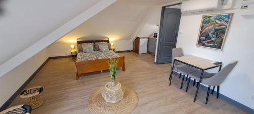 a living room with a bed and a table and a desk at Le 9 - Barachois in Saint-Denis
