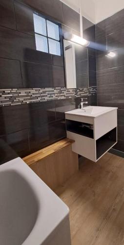 a bathroom with a white sink and a tub at Le 9 - Barachois in Saint-Denis