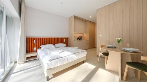 a bedroom with a bed and a table and a kitchen at Prywatne apartamenty w Sea Shell, Sun & Snow in Łukęcin