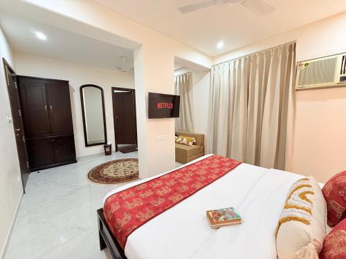 a hotel room with a large bed and a tv at Palm Residences and Suites in Jaipur