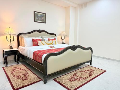 a bedroom with a large bed and two rugs at Palm Residences and Suites in Jaipur