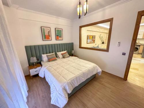 马拉喀什Bel appartement de luxe的一间卧室配有一张带绿色床头板和镜子的床