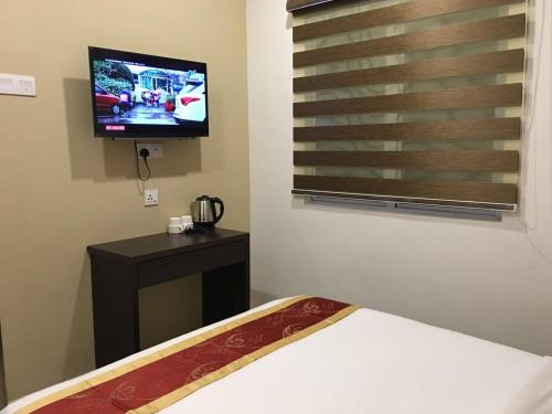 Una televisión o centro de entretenimiento en Global Inn Hotel