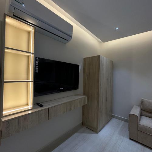 a living room with a flat screen tv on a wall at AN Studios in Al Khobar