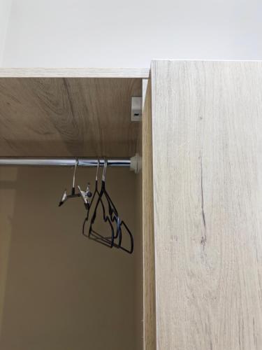 a pair of hangers hanging from a wooden door at AN Studios in Al Khobar