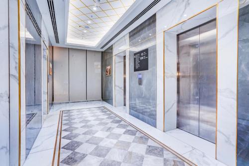 a hallway in a building with a checkered floor at Sunday Hotel & Residences Gurugram in Gurgaon