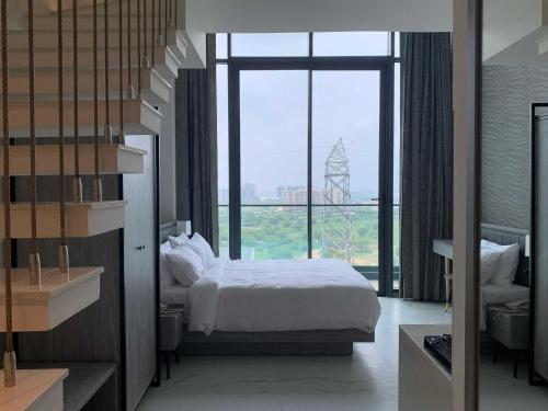 a bedroom with a bed and a large window at Sunday Hotel & Residences Gurugram in Gurgaon