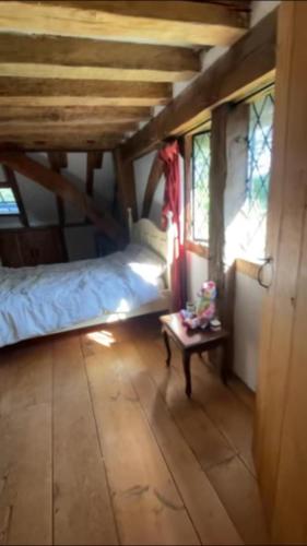a bedroom with a bed and a table in a room at Old Barn in Kirdford