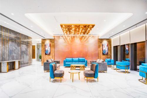 a lobby of a hotel with blue chairs and tables at Sunday Hotel & Residences Gurugram in Gurgaon