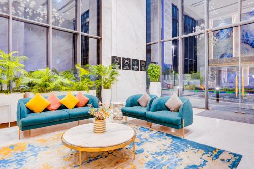 a lobby with two blue couches and a table at Sunday Hotel & Residences Gurugram in Gurgaon
