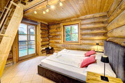 une chambre avec un lit dans une cabane en rondins dans l'établissement GUT Edelweiss, à Kaprun