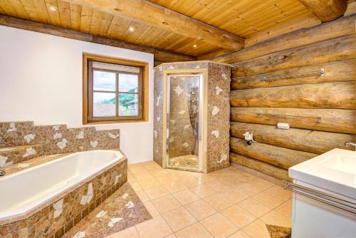 une salle de bain avec une baignoire et un lavabo dans l'établissement GUT Edelweiss, à Kaprun