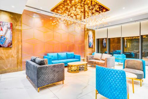 a lobby with blue couches and chairs at Sunday Hotel & Residences Gurugram in Gurgaon