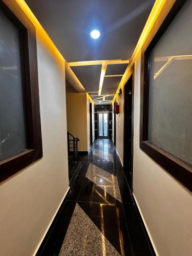 a corridor of a hallway with two windows and a hallwayngth at Hotel kapil royal inn in Rāiwāla