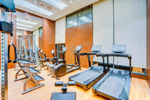a gym with several treadmills and exercise bikes at Sunday Hotel & Residences Gurugram in Gurgaon