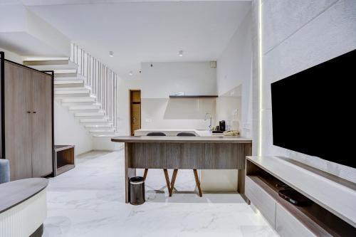 a kitchen with a counter and a large tv on a wall at Sunday Hotel & Residences Gurugram in Gurgaon