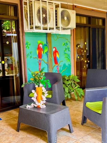 a patio with two parrots painted on the wall at Villas Ela en Bahía Ballena,Uvita Hermosas habitaciones privadas grandes, piscina, cocina, jacuzzi, aire acondicionado, tv y baño privado in Uvita