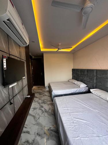 a room with two beds and a flat screen tv at Hotel kapil royal inn in Rāiwāla
