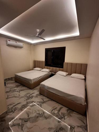 two beds in a room with a ceiling at Hotel kapil royal inn in Rāiwāla