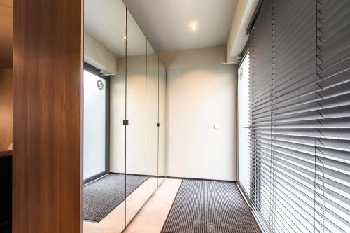 a hallway with sliding glass doors and a walk in closet at Jacuzzi Cinema Shibui 5 in Kaunas