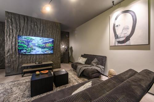 a living room with a couch and a tv at Jacuzzi Cinema Shibui 5 in Kaunas
