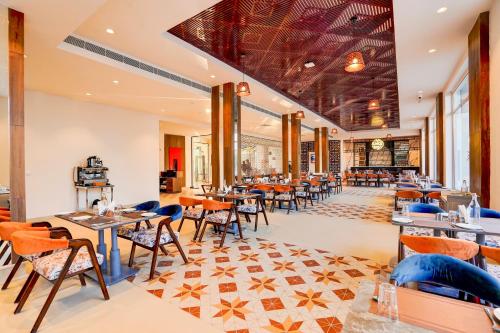 a dining room with tables and chairs at Sunday Resort & Spa Manesar Gurugram in Gurgaon