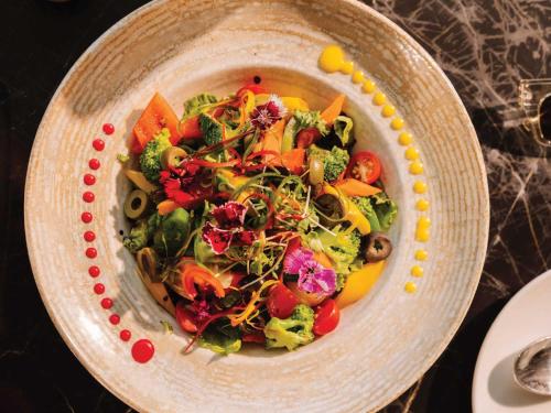 a salad in a bowl on a table at Sunday Resort & Spa Manesar Gurugram in Gurgaon