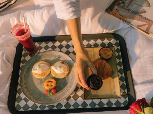 a tray with a plate of donuts and a drink at Sunday Resort & Spa Manesar Gurugram in Gurgaon