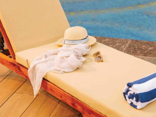 a towel and a hat sitting on a chair at Sunday Resort & Spa Manesar Gurugram in Gurgaon