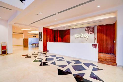 a lobby with a white counter and a red curtain at Sunday Resort & Spa Manesar Gurugram in Gurgaon