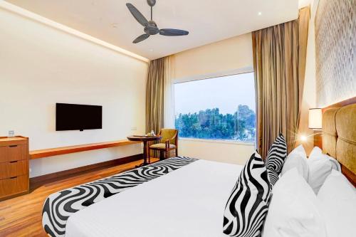 a hotel room with a bed and a television at Sunday Resort & Spa Manesar Gurugram in Gurgaon