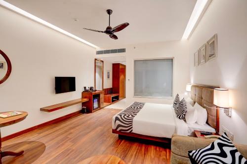 a bedroom with a bed and a ceiling fan at Sunday Resort & Spa Manesar Gurugram in Gurgaon