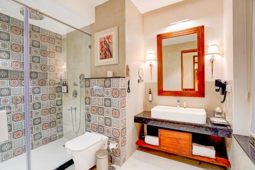 a bathroom with a toilet and a sink and a shower at Sunday Resort & Spa Manesar Gurugram in Gurgaon