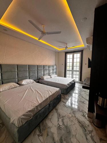 a bedroom with two beds and a ceiling with lights at Hotel kapil royal inn in Rāiwāla