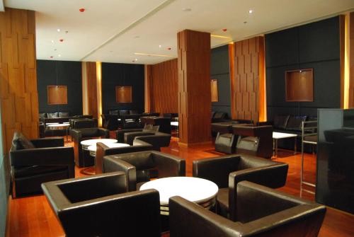 a restaurant with black chairs and tables and tables and chairs at Royal Park Kakinada in Kākināda