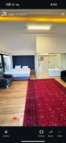 a bedroom with a bed and a red rug at أكواخ الأصاله 
