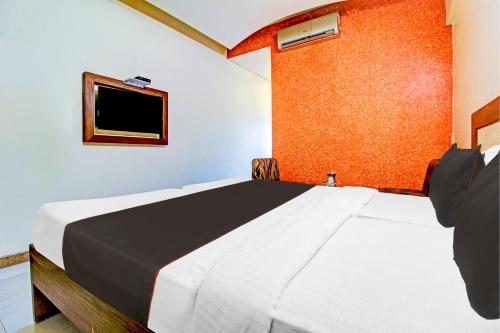 a bedroom with a bed and a tv on the wall at Palette Hotel Pune, MIDC Chinchwad in Chinchiwad