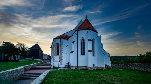 a white church with a steeple on the grass at Jur Georgious in Svätý Jur