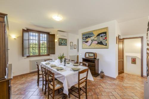a dining room with a white table and chairs at Casa Baiocco in Città della Pieve