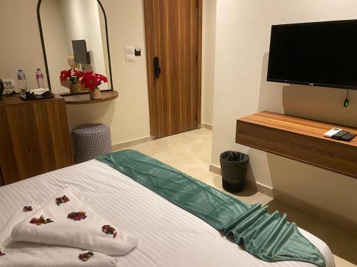 a bedroom with a bed and a flat screen tv at NOMAD PYRAMIDS AND SPHINX Hotel in Cairo
